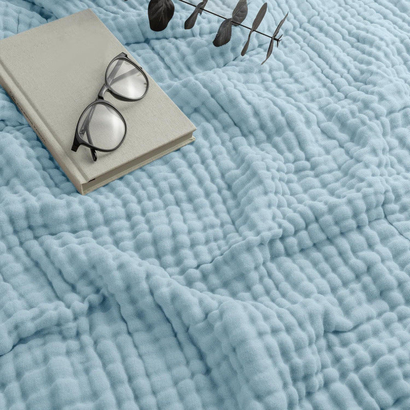 The Cotton Muslin Blanket draped and styled in a modern living room
