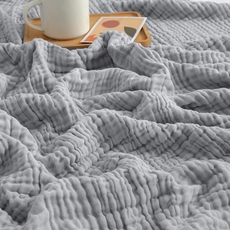 Muslin blanket draped over the edge of a bed